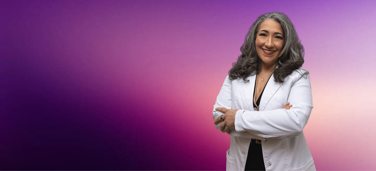 Dr. Andrea Matsumura in a white coat standing against a gradient purple and pink background